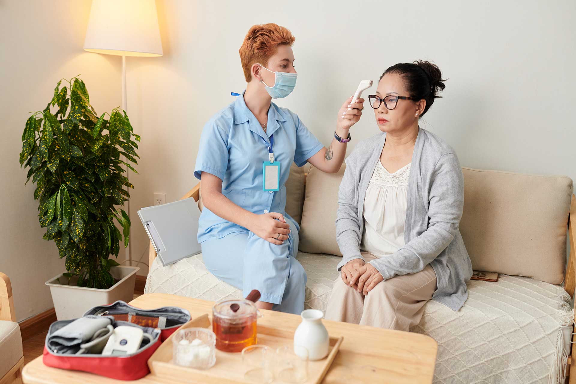 nurse-examining-patient-at-home-HYRZQRT